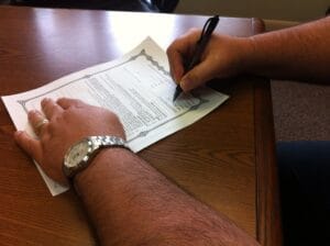 Signing company amendment documents at a desk in Qatar