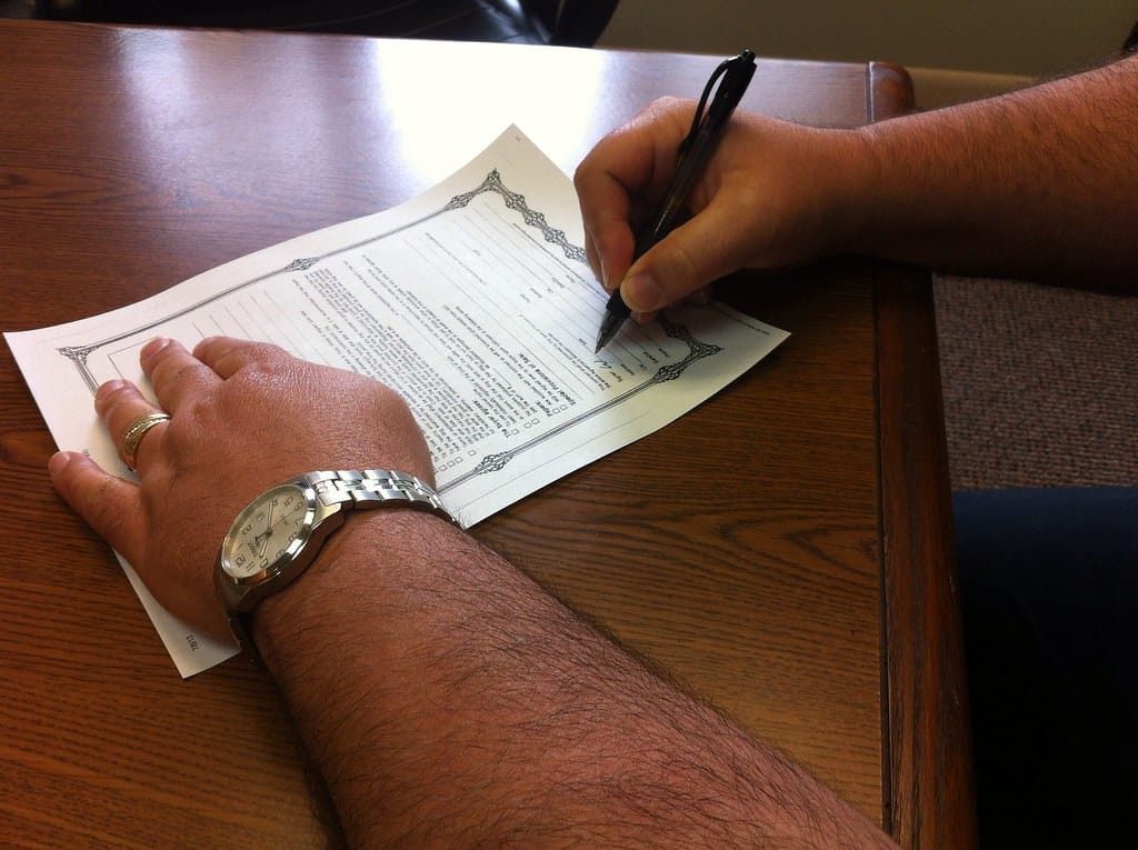 Signing company amendment documents at a desk in Qatar